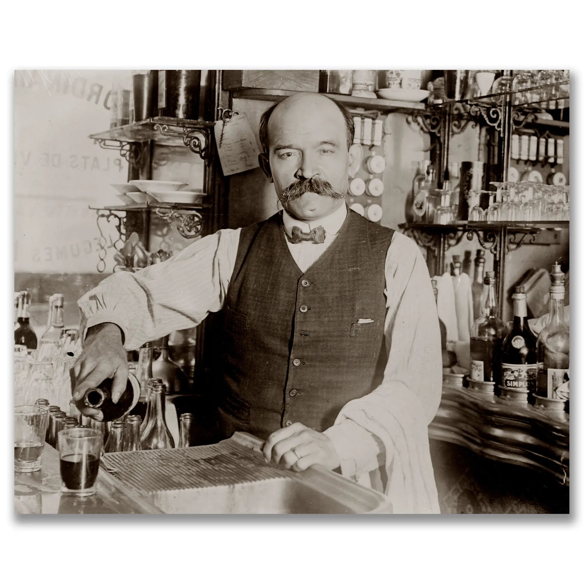 Historic classic prohibition bartender photograph showing distinguished gentleman with handlebar mustache behind ornate saloon bar with elaborate fixtures