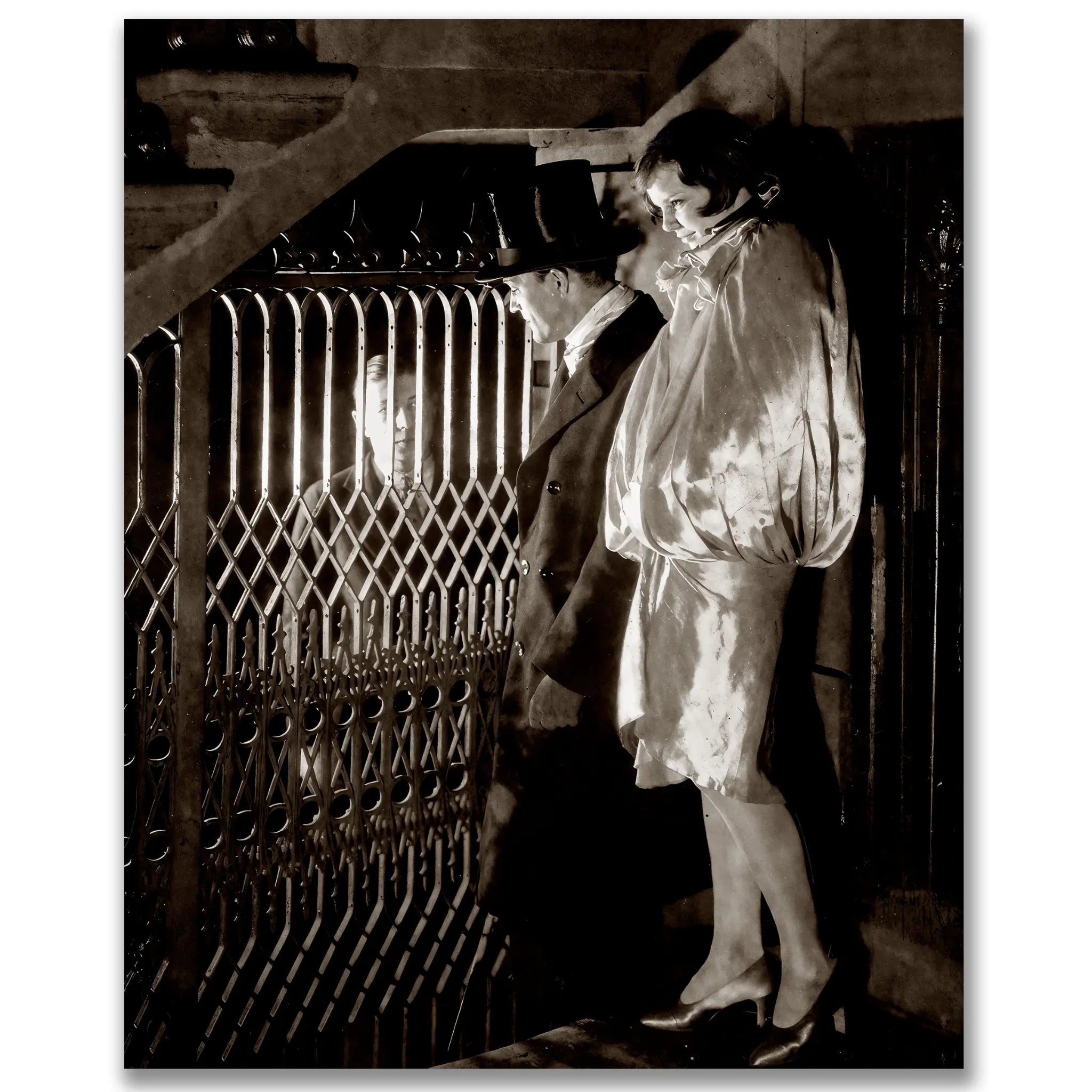 Historic prohibition underground rendezvous photograph showing dramatic encounter between woman in white robes and gentleman behind ornate metal gate in speakeasy setting